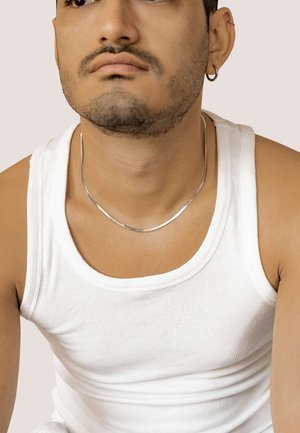 Silbernes Choker-Halsband mit einem glatten, geschwungenen Design. Getragen über einem weißen, gerippten Tanktop, das seine elegante Textur auf der Haut zur Geltung bringt.