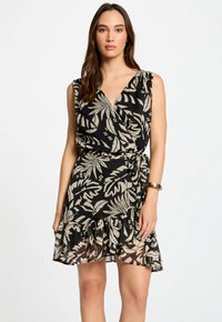 Zwarte jurk met een bloemenpatroon in beige. Heeft een wikkel ontwerp, mouwloze snit en een gerimpelde zoom. Gemaakt van lichte stof.