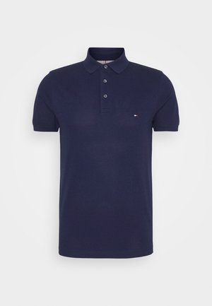 Polo azul marino de algodón con cuello con solapa, tapeta con tres botones y un pequeño logo en el pecho izquierdo. Mangas cortas.