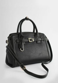 Sac à main en cuir noir avec doubles poignées, détail ceinture à l'avant, quincaillerie dorée et bandoulière réglable sur un fond uni.