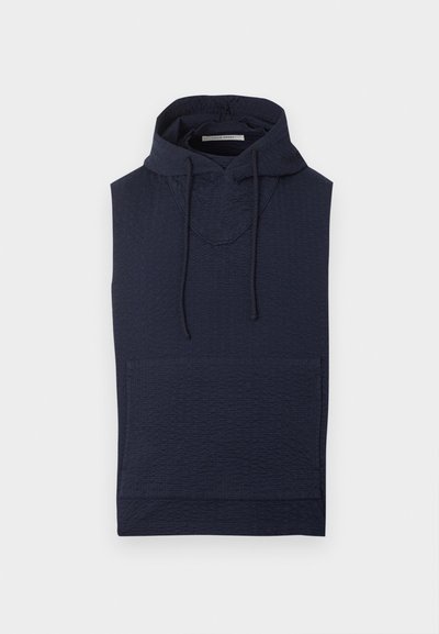 Marineblauwe mouwloze textuur hoodie met voorzak en verstelbare trekkoorden aan de capuchon, plat gelegd op een witte achtergrond.