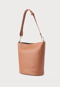 Καφέ δερμάτινη τσάντα τύπου «κουβά» με υφή, που διαθέτει αποσπώμενο ιμάντα, μπροστινή τσέπη και λογότυπο με χρυσή διακόσμηση στη βάση.