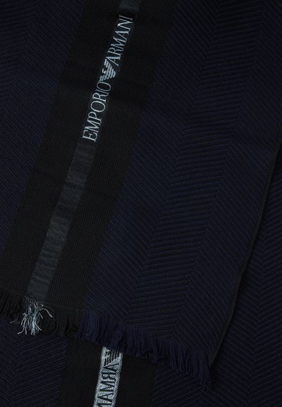 Ciemnoniebieski i czarny szalik z wzorem jodełki, z frędzlami na krawędziach oraz srebrnym logo "Emporio Armani" na czarnej wstążce.