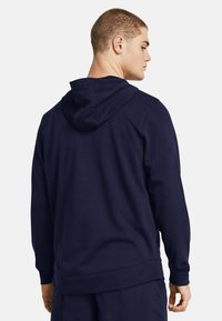 Felpa blu navy realizzata in morbido tessuto, con tasca a marsupio, cappuccio con cordino regolabile e polsini e orlo a costine. Vestibilità standard.