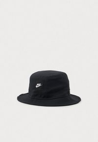 Czarny kapelusz bucket Nike z szerokim brzegiem i białą łatą z logo z przodu, wyeksponowany na jednolitym białym tle.