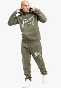 Olīvu zaļas hdodija un sporta bikses komplekts ar lielu baltu "TAPOUT" logotipu. Iespējota kangaroo kabata, regulējams kapuci un ribotās piedurknes.