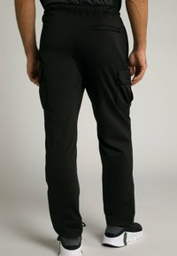 Zwarte joggingsbroek met een elastische taille, zij cargo pockets en een achterzak, met een soepele stof en tapered fit.