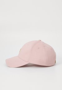 Cappellino da baseball in cotone rosa con visiera curvata, logo con accento dorato sul davanti e fori di ventilazione. Design classico con cinturino regolabile.