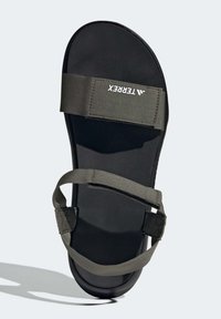 Grønne tekstilrem-sandaler med en mørk gummisåle. Har justerbare remmer og en strukturert fotseng for bedre grep. Merkevaren sin logo er synlig på remmen.