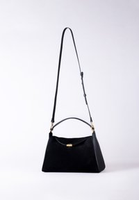 Black suede handbag with a structured triangular shape, featuring a top handle, adjustable strap, and gold-tone hardware accent.