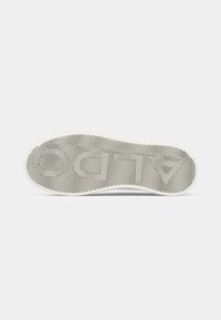 Sole della scarpa con un motivo a spina di pesce testurizzato in grigio con bordi bianchi e logo in rilievo. Materiale liscio e resistente per una migliore aderenza.