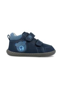 Zapatos de piel azul tipo botín presentan un diseño de oso en el costado, dos correas de velcro y una suela de goma gris con pequeños puntos para mayor tracción.