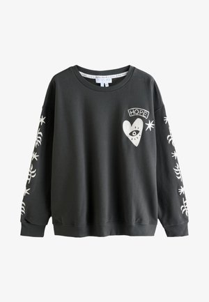 Sort crewneck sweatshirt med hvidt hjerte- og øje-grafik mærket "HOPE" på brystet og hvide stjerner og abstrakte design ned ad begge ærmer.