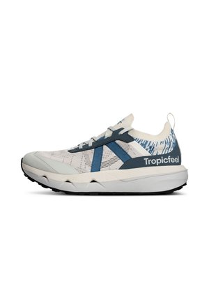 Zapatilla baja en beige claro y azul con parte superior de malla, suela blanca gruesa, suela exterior negra y la marca "Tropicfeel" en el contrafuerte del talón.