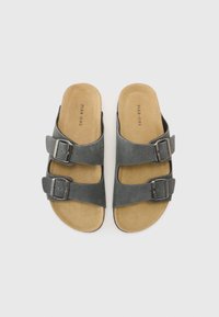 Sandale gri din suede, cu două curele reglabile cu cataramă, baretă de culoare bej moale și talpă plată. Design minimalist, fără modele suplimentare.