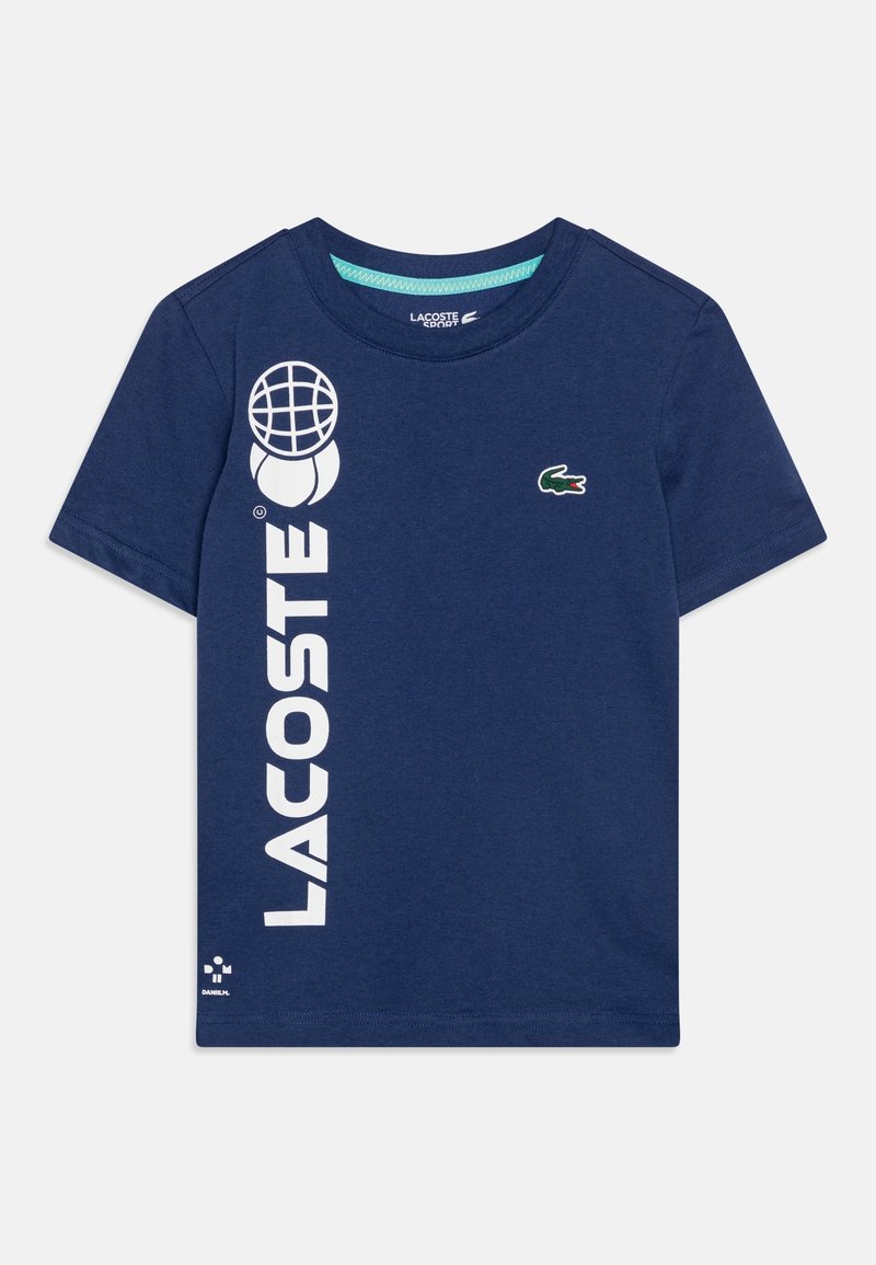 Námořnická modrá bavlněná tričko s výrazným bílým nápisem "LACOSTE", grafikou globu a malým vyšitým zeleným krokodýlem na hrudi.