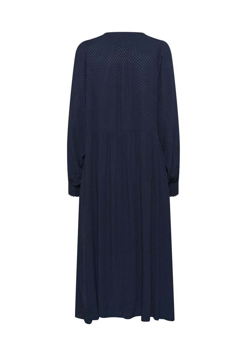 Navyblaues Kleid mit langen Ärmeln, plissiertem Design und strukturiertem Stoff mit kleinen Ausschnittmustern. Fällt unter die Knie.