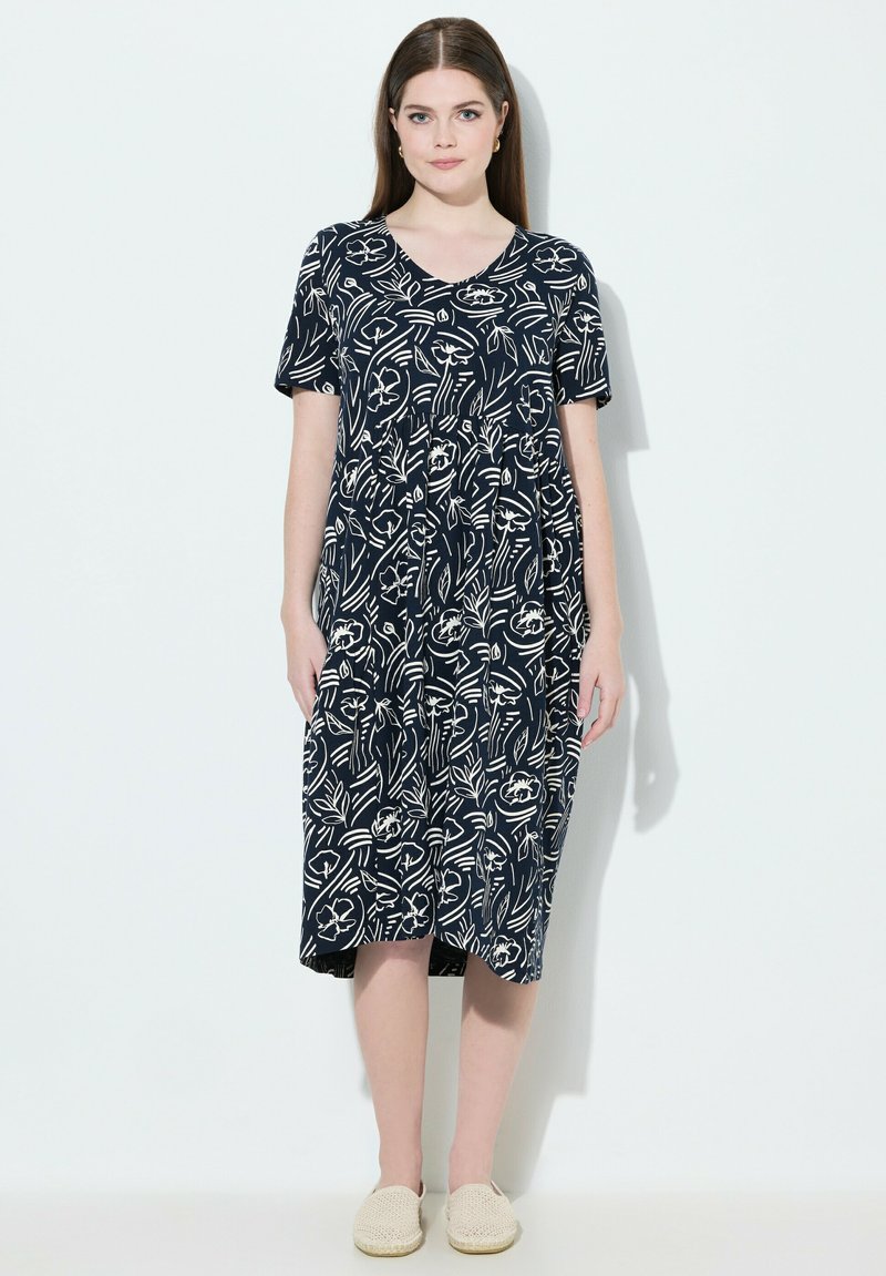 Mekko laivastonsininen kukkakuviolla ja valkoisilla viivoilla, lyhyet hihat, V-pääntie ja keskikalkkoon saakka ulottuva pituus. Kevyt kangas ja rento malli.