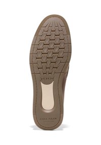 Semelle d'une chaussure marron avec un motif de semelle géométrique, support de voûte plantaire beige et marquage "Cole Haan Grand 360" dans la zone du talon.