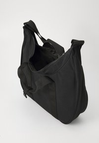 Sac fourre-tout en tissu noir avec fermeture éclair, doté de doubles poignées et d'une forme douce et arrondie. L'intérieur est non doublé et spacieux.