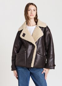 Giacca in ecopelle marrone con colletto in shearling beige, design doppiopetto, grandi tasche e dettagli con bottoni. Finitura texturizzata.