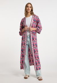 Dolgo, pisan kimono s pisanimi vzorci z roza osnovo, ki je združen z belim notranjim podplatom in odprtim sprednjim delom.
