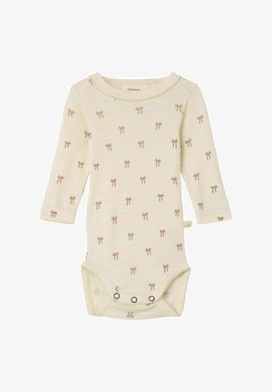 Kreminės spalvos ilgomis rankovėmis bodis, pagamintas iš minkštos medžiagos, su subtiliu šviesiai rudos spalvos mažų kaspinų raštu. Apatinėje dalyje yra snapų užsegimai.