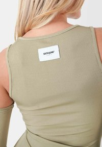 Top in cotone verde oliva a costine con etichetta bianca rettangolare con il logo "SIXTH JUNE" sul retro; design aderente e texture morbida.