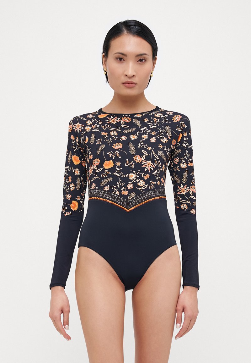 Maillots de bain noir à manches longues présentant un motif floral orange sur le torse, avec un bas noir uni et une bordure contrastée en crochet.
