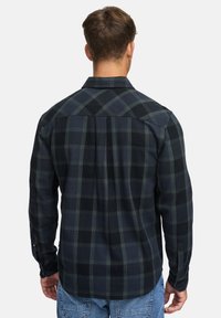 Flanellhemd in Marineblau und Grün kariert, mit Kentkragen, Knopfmanschetten und einer Passe. Weicher Stoff mit geradem Saum.