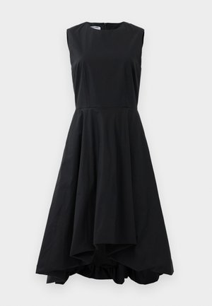 Ärmelloses schwarzes Midikleid mit figurbetontem Oberteil und ausgestelltem, asymmetrischem Saum, das vor einem schlichten Hintergrund hängt.