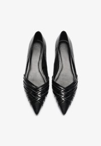 Bailarinas negras de cuero con punta afilada y tiras trenzadas en la parte delantera, textura suave y un diseño interior sencillo.
