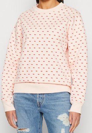 Felpa rosa chiaro con motivo a pois rossi, scollo rotondo, polsini e orlo a costine. Realizzata in morbido tessuto, presenta una vestibilità comoda.