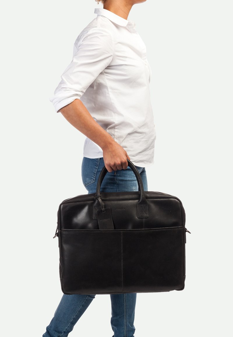 Schwarze Lederaktentasche mit glatter Textur, zwei oberen Griffen, Vordertasche und Gepäckanhänger. Die Abmessungen deuten auf eine Kapazität für einen Laptop oder Dokumente hin.