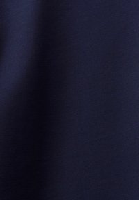 Marinblått tyg med en slät, något texturerad yta. Enhetlig färg utan synliga mönster eller utsmyckningar.