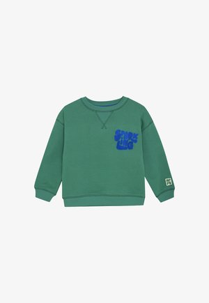 Groene sweatshirt met lange mouwen en blauwe tekst "SPARKLING" op de borst, en een klein wit label met groene letters op de rechtermanchet.