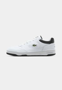 Adidași din piele albă cu accente negre, vârf rotunjit, șireturi plate, detalii perforate și logo-ul Lacoste pe lateral. Talpă texturată.