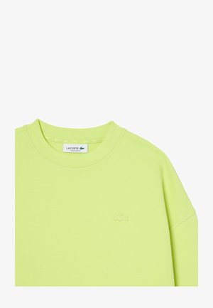 Hellgrüner, oversized Lacoste-Sweatshirt mit Rundhalsausschnitt und tonalem, gesticktem Krokodil-Logo auf der linken Brust.