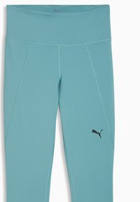 Κολάν Puma σε ανοιχτό μπλε χρώμα με απαλή υφή, ψηλή μέση και μαύρο λογότυπο. Διαθέτει λεπτομέρειες πανελ για εφαρμογή που αγκαλιάζει το σώμα.