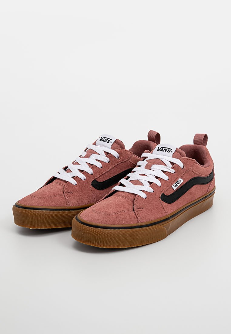 Różowe zamszowe sneakersy z czarnym paskiem po bokach, białymi sznurowadłami i gumową podeszwą. Posiadają logo na języku i zewnętrznej stronie.