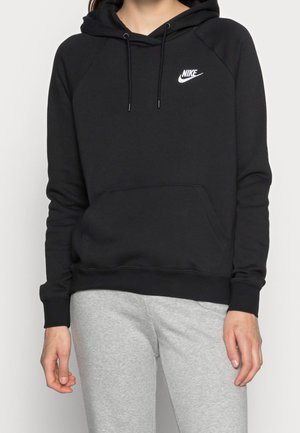 Černá mikina Nike s kapucí a přední kapsou, sice šňůrkou na stažení a bílým logem. Má žebrované manžety a lem, vyrobená z jemné směsi bavlny.