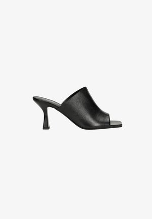 Mules en cuir noir avec une ouverture à l'avant, un design supérieur courbé, et un talon de hauteur intermédiaire effilé avec une surface texturée.