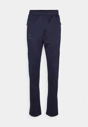 Marineblå, strukturerede sweatpants med elastisk talje, sidelommer med lynlås og diskret logo. Aftagende design med moderne pasform.