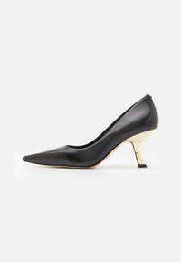 Scarpa nera in pelle con tacco alto, punta affilata e un'accentuazione dorata sul tacco. Texture liscia e silhouette elegante.