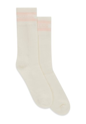 Chaussettes à côtes blanches cassées avec une fine bande rose pâle et un texte discret près du bord supérieur, posées à plat sur un fond blanc.