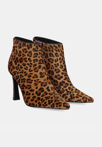 Botines de animal print de leopardo, material de piel sintética, puntera afilada, tacón de aguja de 9 cm, detalles en negro brillante, cierre de cremallera lateral.