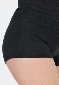 Pantaloni shorts neri elasticizzati realizzati in un tessuto morbido e texture, caratterizzati da un design aderente e bordi puliti, che mettono in risalto la pelle liscia delle gambe.