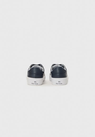 Navy leather sneakers with white soles, featuring a smooth finish and minimal design. "PS" logo and "Paul Smith" printed on the heel.