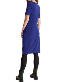 Robe bleue à manches courtes et col rond, dotée d'une taille ajustée et d'une hem au niveau des genoux, associée à des leggings noirs et des bottes.