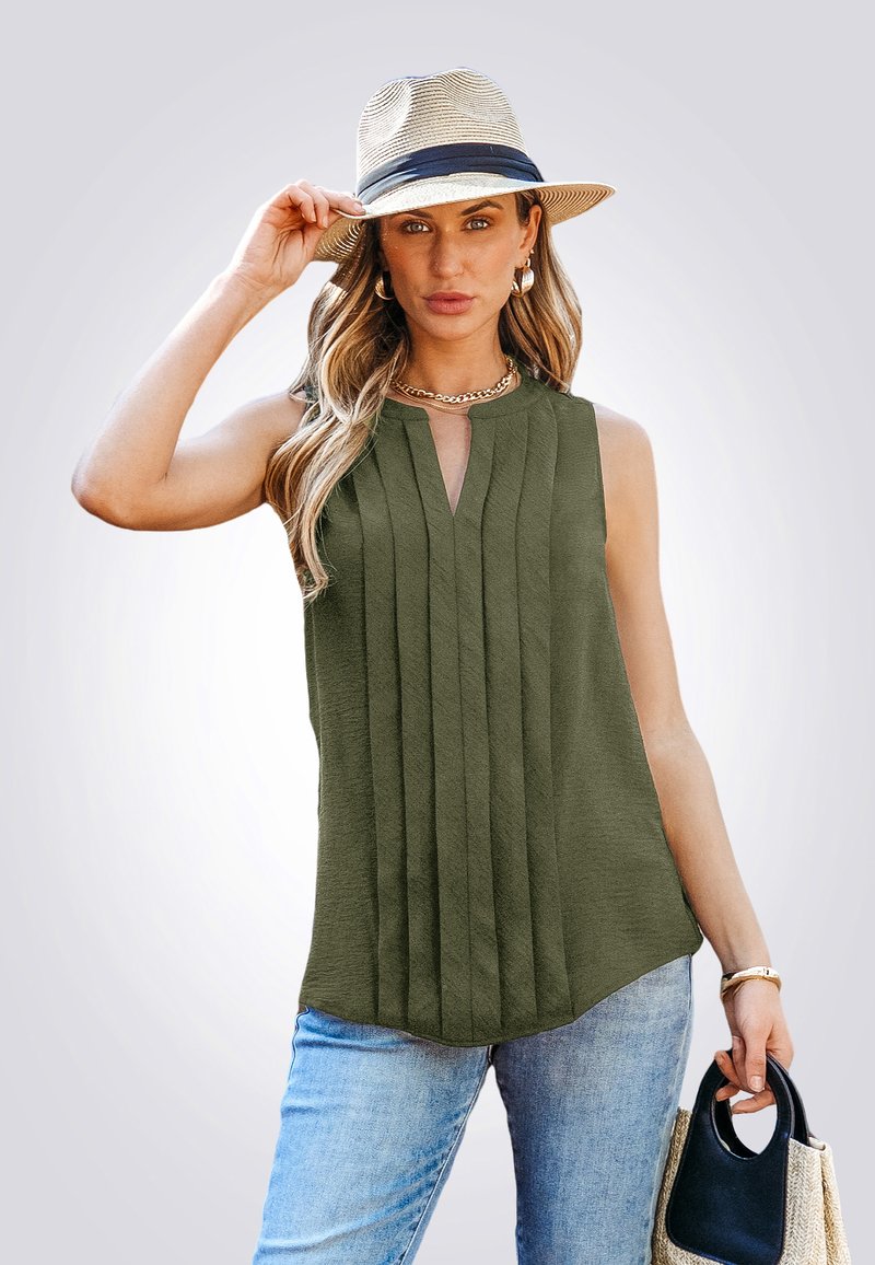 Top sin mangas de color verde oliva con pliegues verticales, escote en V, textura suave; combinado con jeans de mezclilla azul claro y un sombrero de paja con cinta azul marino.